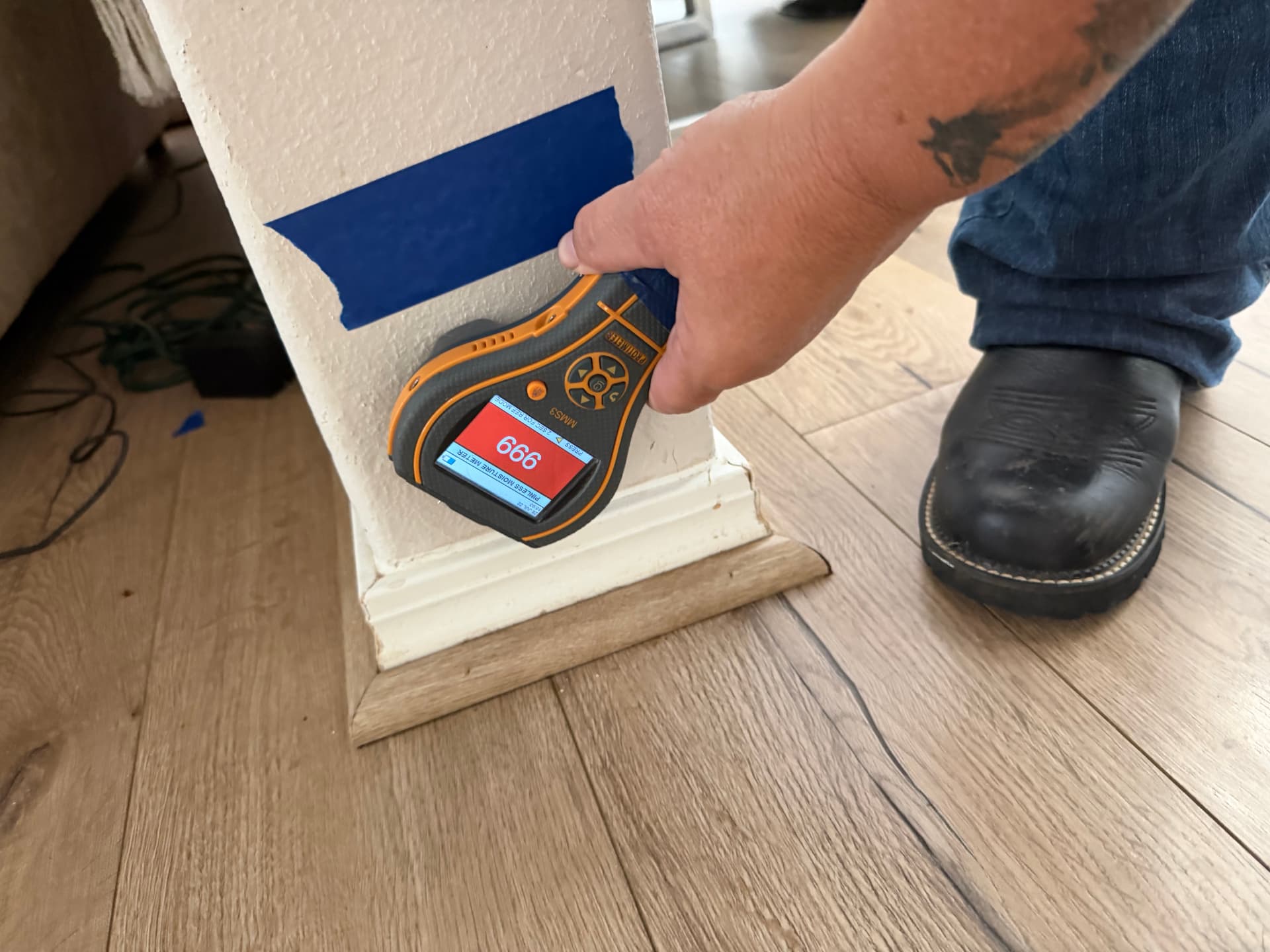 Protimeter MMS3 moisture meter reading 999 on a drywall pillar that appears dry on the surface